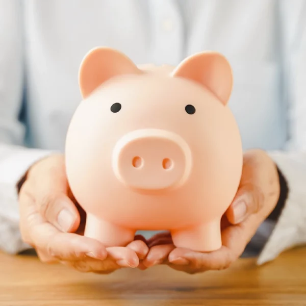 A doctor holding a piggy bank
