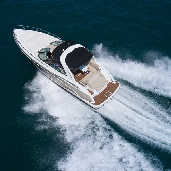 An aerial view of a white boat moving through deep blue water.