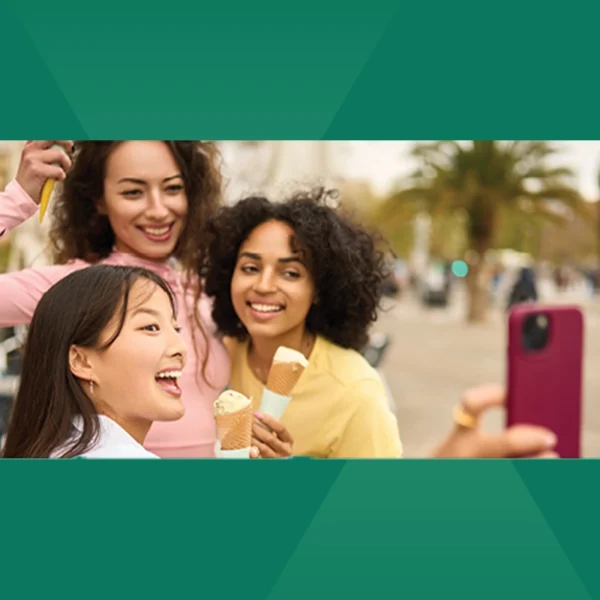 Three friends taking a photo together while enjoying their ice cream.